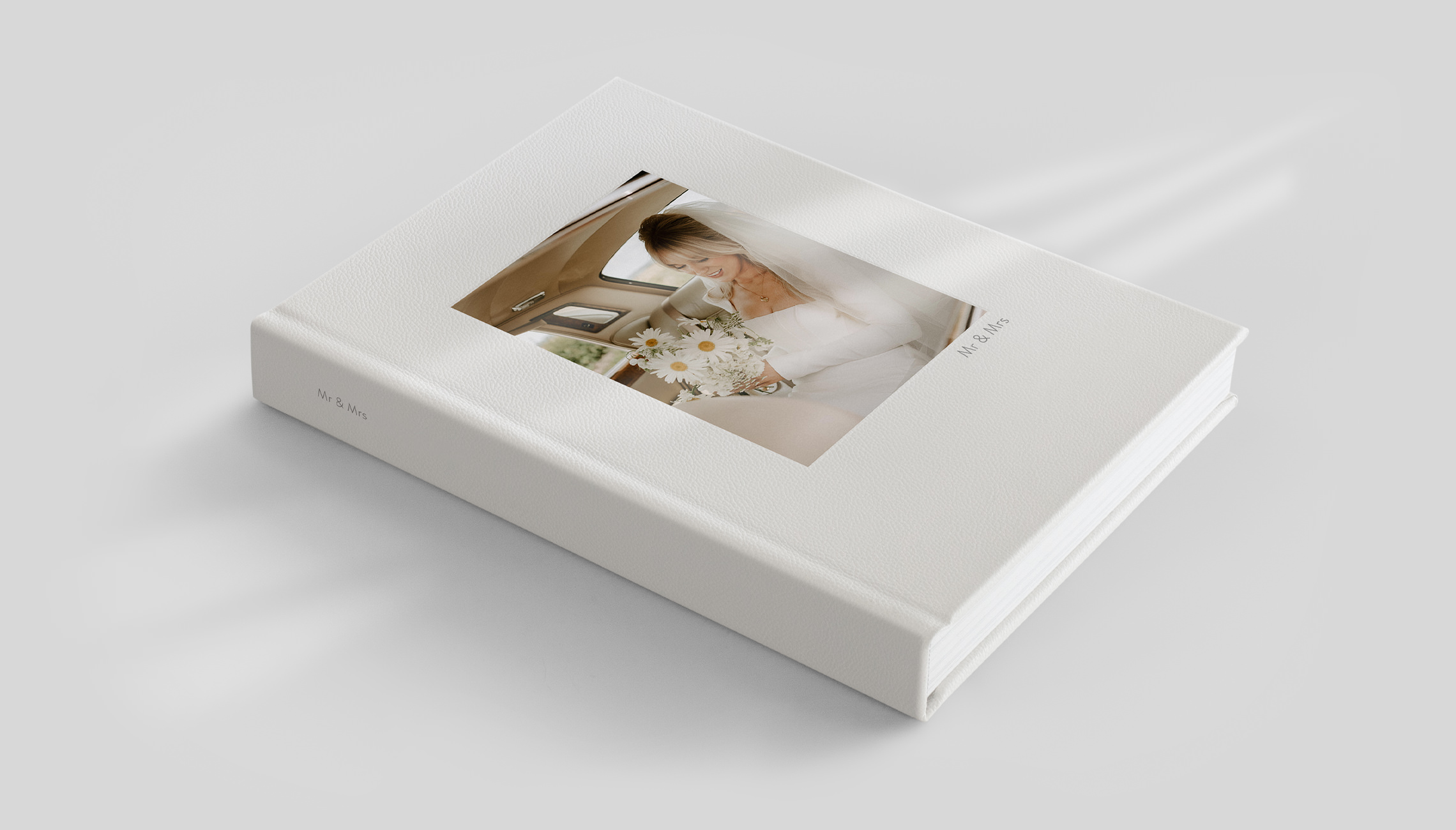 Pile de trois albums photo carrés avec une photo d'un jeune garçon sur les épaules de son père sur la couverture de l’album du dessus